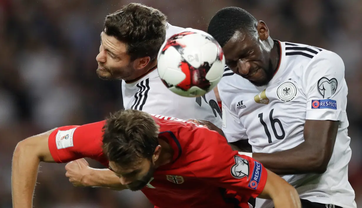 Bek Norwegia, Jorgen Skjelvik berebut bola dengan dua pemain Jerman Jonas Hector dan Antonio Ruediger saat bertanding pada Kualifikasi Piala Dunia 2018 di Stuttgart, Jerman,(4/9). Jerman menang telak atas Norwegia 6-0. (AP Photo/Matthias Schrader)