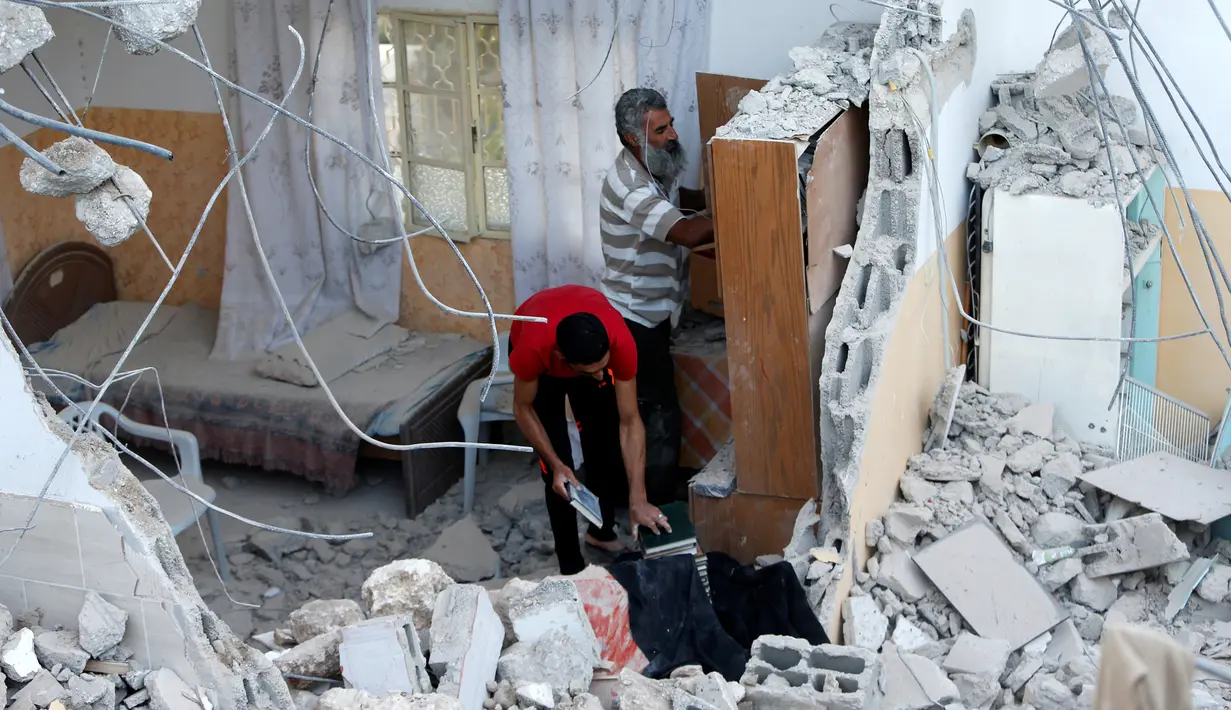 Warga Palestina memeriksa kondisi rumah pejuang Hamas Mohammad Al-Fakih yang ditembak mati oleh pasukan Israel di desa Tepi Barat Surif, dekat Hebron, (27/7). Serangan itu menewaskan satu pejuang Hamas, Mohammad Al-Fakih. (REUTERS/Mussa Qawasma)