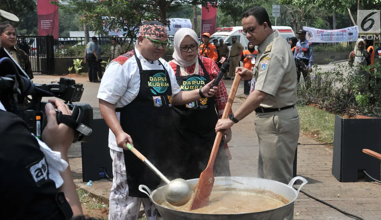Gubernur DKI Jakarta Anies Baswedan disaksikan istri Fery Farhati dan chef Ragil memasak salah satu menu olahan daging kurban saat peluncuran Dapur Kurban di Monas, Jakarta, Senin (12/8/2019). (merdeka.com/Iqbal S. Nugroho)
