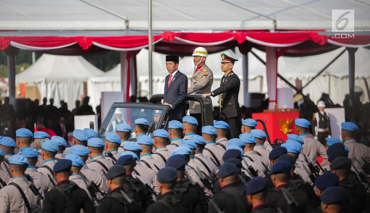 Presiden Joko Widodo (kiri di atas mobil) selaku inspektur upacara memeriksa barisan saat peringatan HUT Ke-73 Bhayangkara di kawasan Monas, Jakarta, Rabu (10/7/2019). Penyelenggaraan perayaan HUT Bhayangkara ini tertunda dari jadwal semestinya pada 1 Juli. (Liputan6.com/Faizal Fanani)