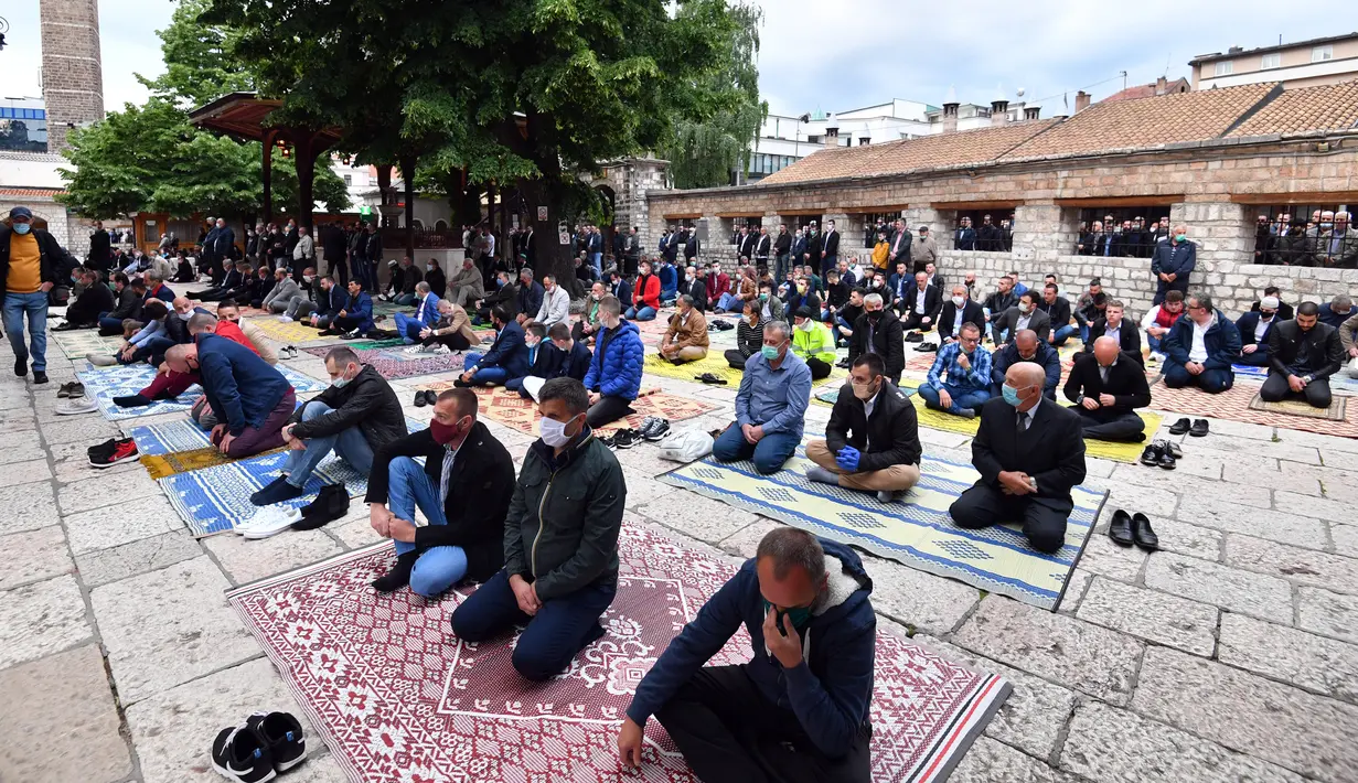 Umat muslim melaksanakan salat Idul Fitri di Masjid Gazi-Husref Bey, Sarajevo, Bosnia, Minggu (24/5/2020). Jemaah dibatasi dan mengenakan masker untuk mencegah penyebaran virus corona COVID-19. (ELVIS BARUKCIC/AFP)