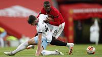 Pemain Manchester United, Paul Pogba, berebut bola dengan pemain West Ham United, Declan Rice, pada laga Premier League di Stadion Old Trafford, Rabu (22/7/2020). Kedua tim bermain imbang 1-1. (Clive Brunskill/Pool via AP)