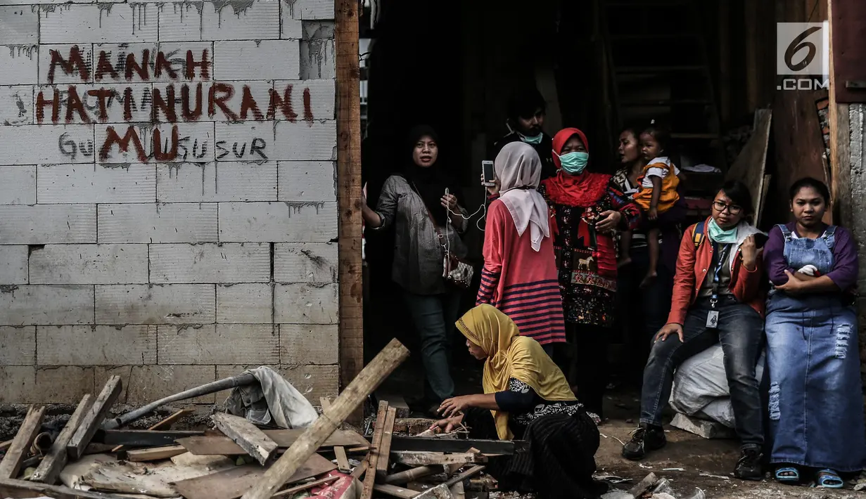Sejumlah warga saat penertiban bangunan di kawasan bantaran Kali Ciliwung, Kelurahan Bukit Duri, Tebet, Jakarta, Selasa (11/7). Sebanyak 345 bidang bangunan ditertibkan hari ini dengan target 333 kepala keluarga (KK). (Liputan6.com/Faizal Fanani)