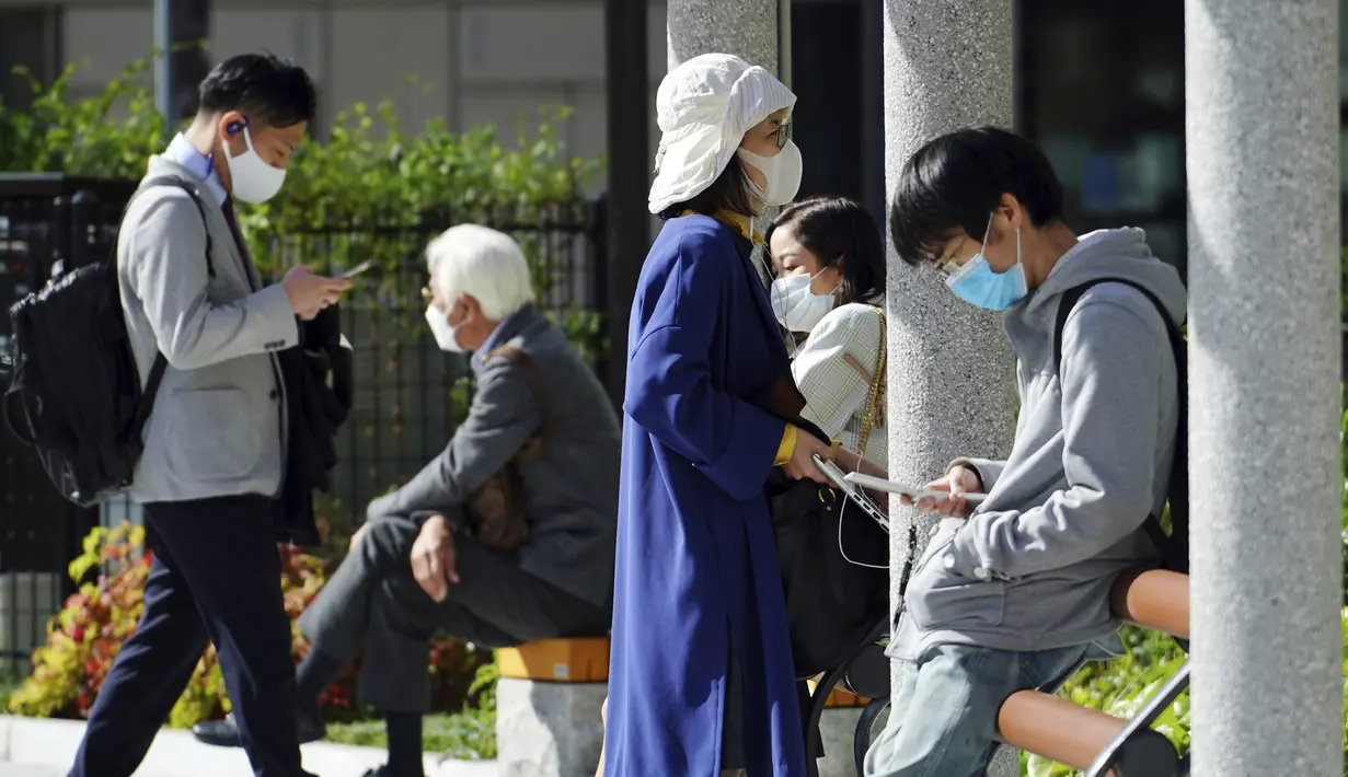 Orang-orang yang mengenakan masker pelindung untuk membantu mengekang penyebaran virus corona COVID-19 mengunjungi taman di Tokyo, Jepang, Kamis (15/4/2021). Tokyo mengonfirmasi lebih dari 700 kasus baru COVID-19 pada 15 April 2021. (AP Photo/Eugene Hoshiko)