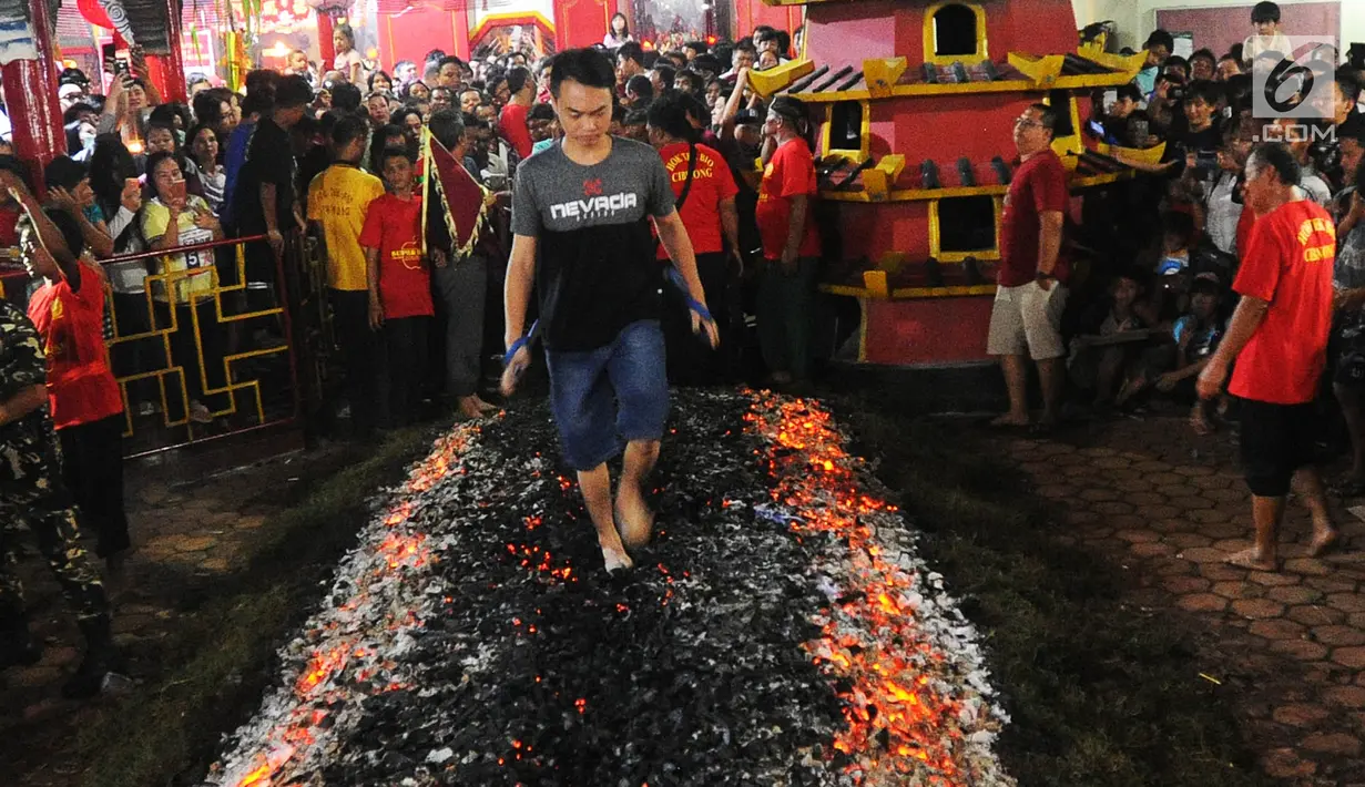 Warga melakukan atraksi Tahwe atau menginjak bara api di Hok Tek Bio Cibinong, Bogor, Sabtu (17/3). Tradisi injak bara tersebut dalam rangka rangkaian Sejit (ulang tahun) Kongco Ho Tek Tjeng Sin atau Dewa Bumi. (Merdeka.com/Arie Basuki)