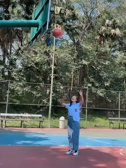 Usai pemotretan dengan seragam SMA di lapangan basket, Happy Asmara terlihat sumringah dengan berusaha memasukan bola basket ke ring. Gaya kece Happy Asmara ini menyita perhatian para fansnya yang terpukau dengan penampilannya. (Liputan6.com/IG/@happy_asmara77)