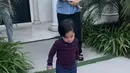 Nikita sambil menggendong putranya tampil mengenakan kemeja baby blue dipadukan celana hitam panjang. Rambutnya diikat ke belakang. [@yorafebrina]