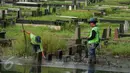 Petugas mengukur tinggi air di area Tempat Pemakaman Umum (TPU) Tanah Kusir, Jakarta, Selasa (25/4). Di TPU Tanah Kusir ini karena kerap tergenang banjir ketika terjadi hujan lebat. (Liputan6.com/Gempur M. Surya)