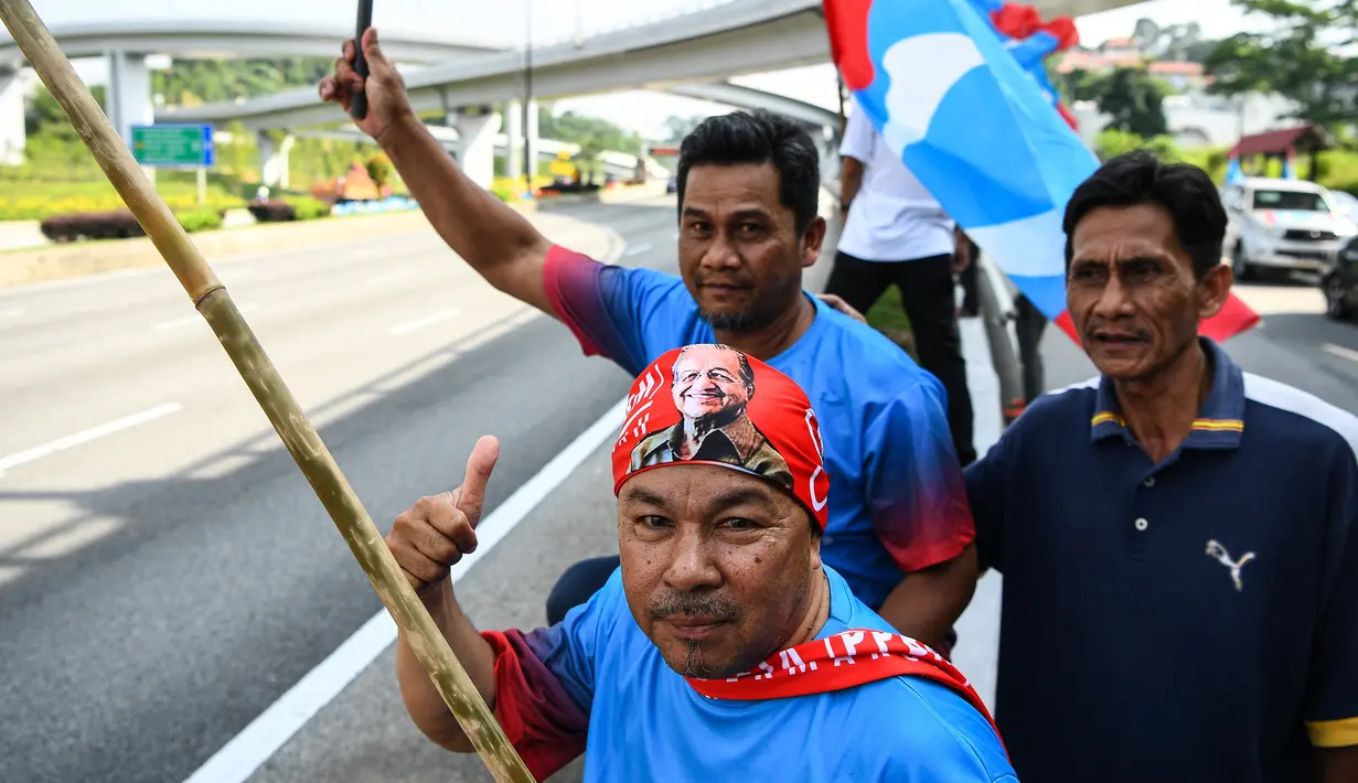 Pendukung Pakatan Harapan memadati jalan menuju Istana Negara menjelang pelantikan Mahathir Mohamad sebagai Perdana Menteri Malaysia di Kuala Lumpur, Kamis (10/5). Mahathir akan menjadi perdana menteri ketujuh Negeri Jiran. (AFP/Manan VATSYAYANA)