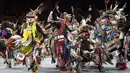 Penampilan para penari saat mengikuti Grand Entry of the Denver March Powwow di Denver, Colorado (24/3). Para penari mengenakan pakaian tradisional serta hiasan kepala, sepatu dan syal dari sukunya masing-masing yang unik. (AFP/Jason Connolly)