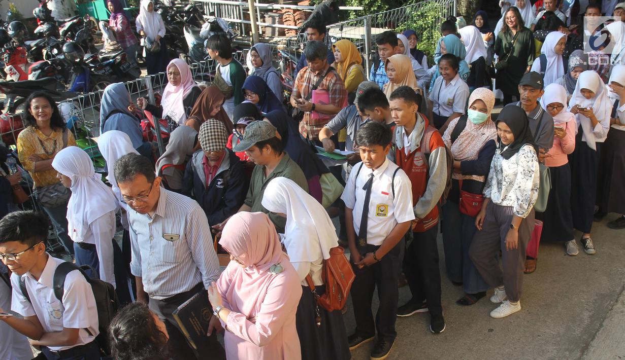 Antrean siswa dengan orangtua murid saat akan mengikuti seleksi Penerimaan Peserta Didik Baru (PPDB) di SMAN 1 Depok, Kota Depok, Jawa Barat, Selasa (18/6/2019). Sistem PPDB Jawa Barat berlangsung pada tanggal 17-22 Juni 2019. (Liputan6.com/Herman Zakharia)