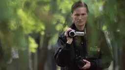 Seorang pemburu hantu dari hantu "Paranormal Investigator" berusaha merekam aktivitas gaib di pusat pemakaman tua di Wina, Austria, 20 Oktober 2016. Pemakaman ini disinyalir memiliki aura mistis yang kental dengan aktivitas makhluk halus. (JOE KLAMAR/AFP)