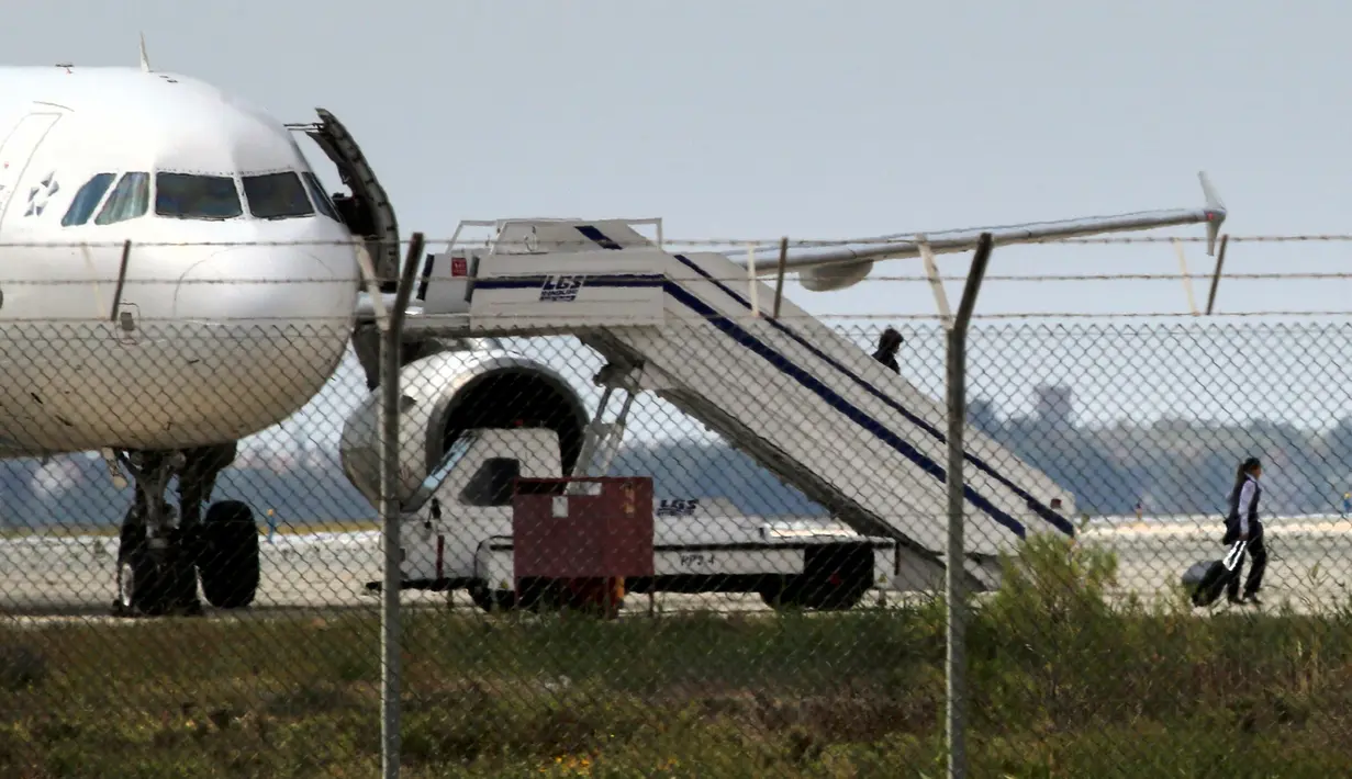 Kru pesawat milik maskapai Mesir, EgyptAir, dibebaskan oleh pembajak di Bandara Larnaca, Siprus, Selasa (29/3). Pesawat yang bertolak dari kota Alexandria menuju Kairo itu dibajak dan dipaksa mendarat di Siprus. (REUTERS/Yiannis Kourtoglou)