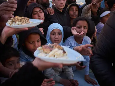 Para pengungsi menunggu untuk menerima makanan sumbangan di samping tenda-tenda yang mereka gunakan sebagai tempat berlindung setelah melarikan diri dari serangan udara Israel di Lebanon selatan, Beirut, Lebanon, Senin 6 April 2026. Dukungan Hizbullah terhadap Iran membuat serangan Israel ke Lebanon semakin menjadi. (AP Photo/Emilio Morenatti)