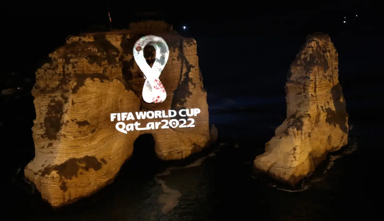 Batu karang 'Raouche' yang terkenal diproyeksikan dengan logo resmi Piala Dunia FIFA Qatar 2022 di Beirut, Lebanon pada Selasa (3/9/2019). Lambang itu juga diluncurkan secara serentak di 24 kota besar lainnya di seluruh dunia. (AP Photo/Hussein Malla)