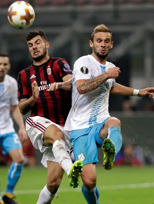 Pemain AC Milan, Patrick Cutrone berebut bola dengan pemain HNK Rijeka, Rijga Dario Zuparic dalam laga Grup D Liga Europa di San Siro, Kamis (28/9). Bertindak sebagai tuan rumah, Rossoneri –julukan Milan– sukses meraih kemenangan 3-2. (AP/Luca Bruno)