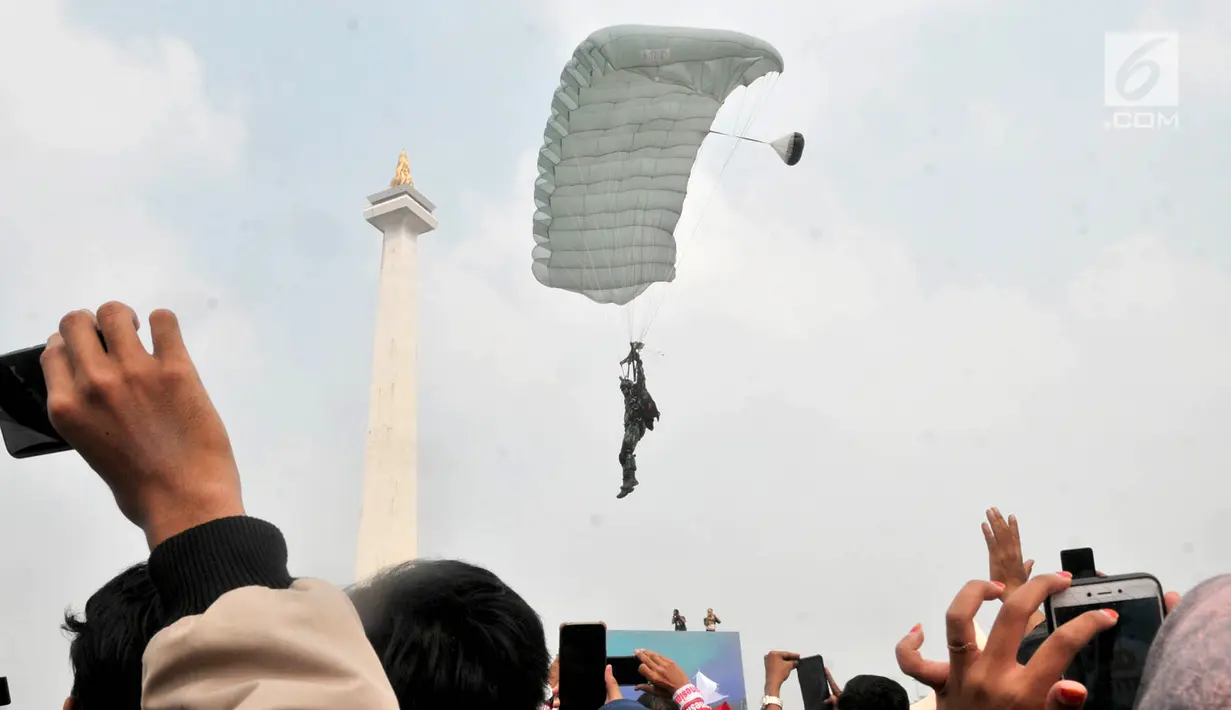 Penerjun payung bersiap mendarat saat Festival Damai Millenial Road Safety di Monas, Jakarta, Minggu (23/6/2019). Aksi puluhan penerjun payung TNI-Polri ini menjadi perhatian warga di akhir acara Festival Damai. (merdeka.com/Iqbal Nugroho)