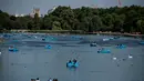 Sejumlah warga mendayung perahu di dekat Serpentine di Hyde Park di London, Inggris (5/7). Sinar matahari yang hangat dimanfaatkan warga Inggris untuk berjemur dan bersantai dengan keluarga atau teman. (AFP Photo/Chris J Ratcliffe)