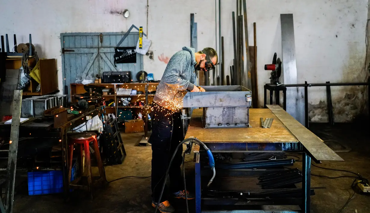 Mantan narapidana Mauro Rodr guez bekerja di toko besi di Penjara Punta de Rieles, Montevideo, Uruguay, 20 Mei 2019. Di sini, Rodr guez bekerja memperbaiki mesin untuk membuat blok semen. (AP Photo/Matilde Campodonico)