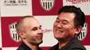 Mantan pemain Barcelona, Andres Iniesta (kiri) berpelukan dengan pemilik klub Vissel Kobe, Hiroshi Mikitani saat konferensi pers di Tokyo, Jepang, Kamis (24/5). Iniesta resmi bergabung dengan Vissel Kobe. (Behrouz MEHRI/AFP)