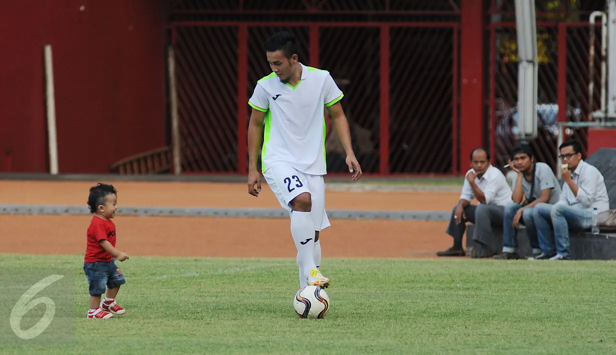 Pesepakbola klub Persija Jakarta, Gunawan DC (kedua kiri) bercengrama dengan seorang bocah disela-sela latihan di Stadion GBK Jakarta, Rabu (29/7/2015). Latihan ini untuk mengisi kekosongan kompetisi pasca pembekuan PSSI. (Liputan6.com/Helmi Fithriansyah)