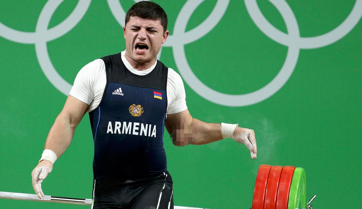 Atlet angkat besi Armenia, Andranik Karapetyan melepaskan barbel ke matras usai mengalami cedera horor ketika tampil pada Olimpiade 2016 di Rio de Janeiro, Rabu (10/8). Siku Karapetyan patah saat hendak mengangkat beban 195 kilogram (REUTERS/Stoyan Nenov)