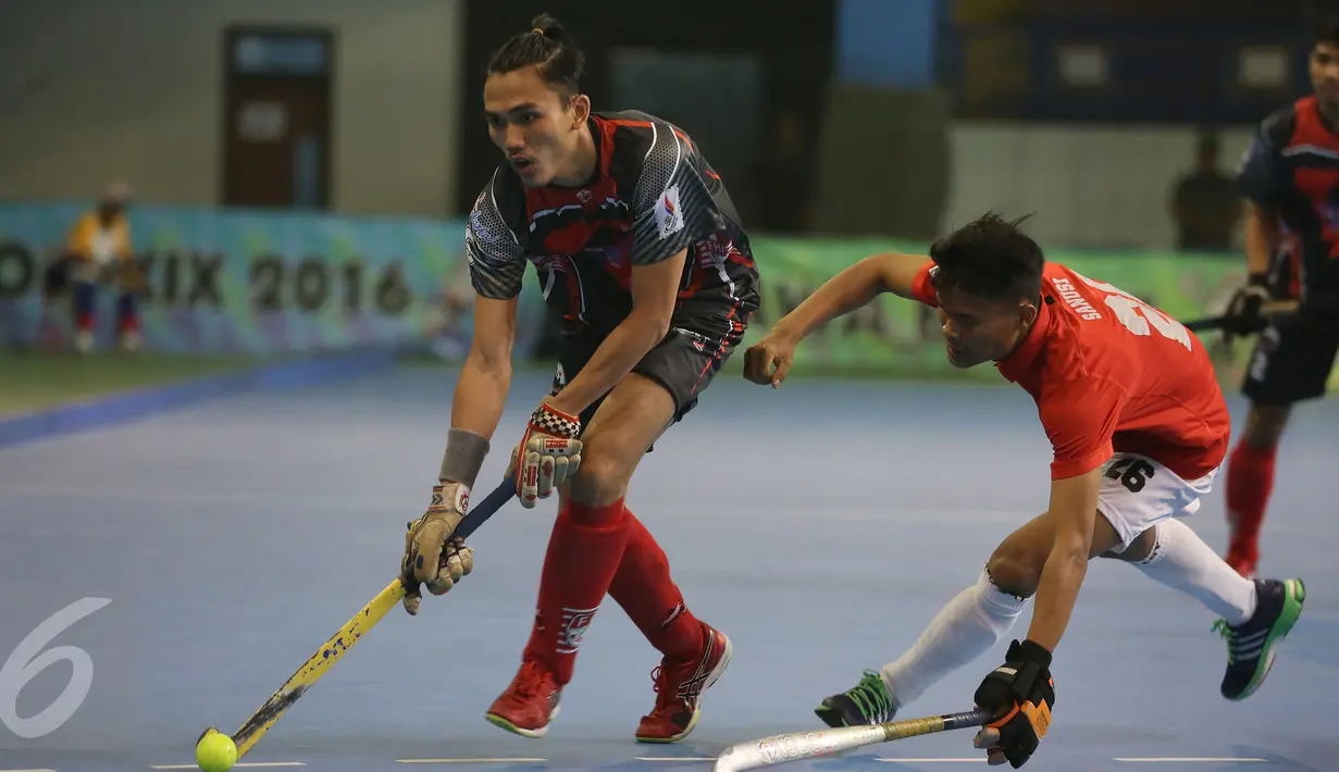 Kapten tim hoki putra DKI Jakarta, Daarul Quthni (kiri) mengecoh pemain Jawa Barat saat laga final hoki PON XIX Jabar di Gymnasium UPI, Bandung, Senin (19/9). Jawa Barat menundukkan DKI Jakarta dengan skor 3-1. (Liputan6.com/Helmi Fithriansyah)