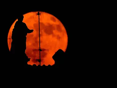 Bulan purnama, yang dikenal sebagai 'Bulan Stroberi', muncul di atas Fori Imperiali di pusat kota Roma, Italia, 11 Juni 2025. (Tiziana FABI/AFP)
