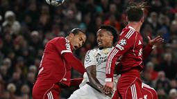 Bek Real Madrid asal Brasil, Eder Militao (tengah) berebut bola dengan bek Liverpool asal Belanda, Virgil van Dijk (kiri) dalam pertandingan pekan keempat Liga Champions 2025-2026 di Stadion Anfield, Inggris, pada Selasa 4 November 2025 waktu setempat atau Rabu (5/11/2025) dini hari WIB. Tampil di bawah tekanan, Real Madrid terus mencoba mengambil inisiatif serangan. (Paul ELLIS/AFP)