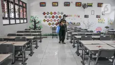 Petugas menyemprotkan disinfektan pada salah satu ruang kelas di SD Negeri Malaka Jaya 07 Pagi, Jakarta, Kamis (26/8/2021). Pemprov DKI berencana membuka kembali sekolah untuk pembelajaran tatap muka terbatas pada Senin (30/8) setelah status PPKM turun ke level 3. (merdeka.com/Iqbal S Nugroho)