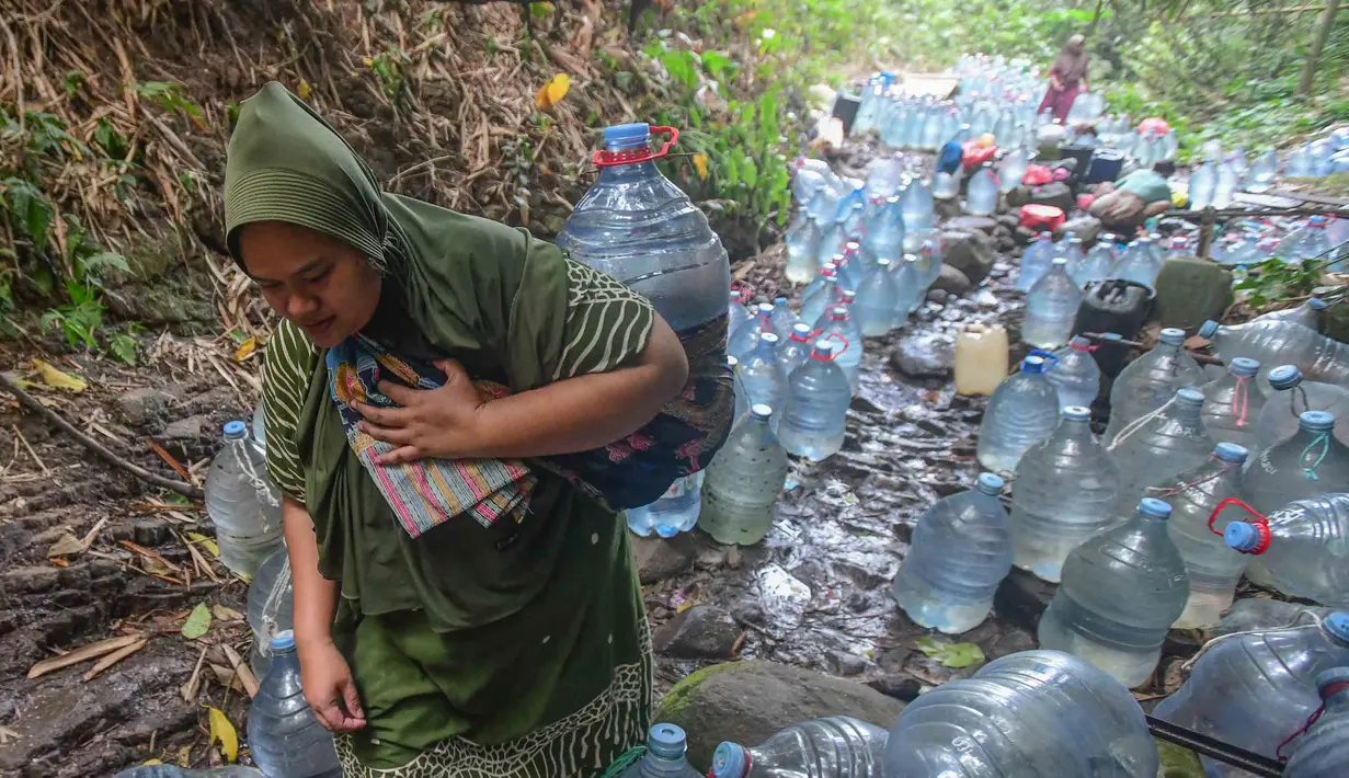 Warga  mengambil air untuk minum dan kebutuhan mck rumah  di sumber mata air Sumur Bendung, Gunung Batur, Kota Cilegon, Banten, Minggu, (15/7/2026). (KLY/Arie Basuki)