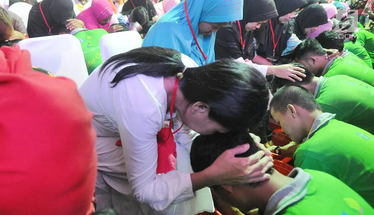 Para orangtua memegang kepala anak mereka saat ritual membasuh kaki ibu di Lembaga Pembinaan Khusus Anak (LPKA) Kelas 1 Tangerang, Banten (17/4). Kegiatan ini dilakukan serentak di seluruh LPKA di Indonesia. (Merdeka.com/Arie Basuki)