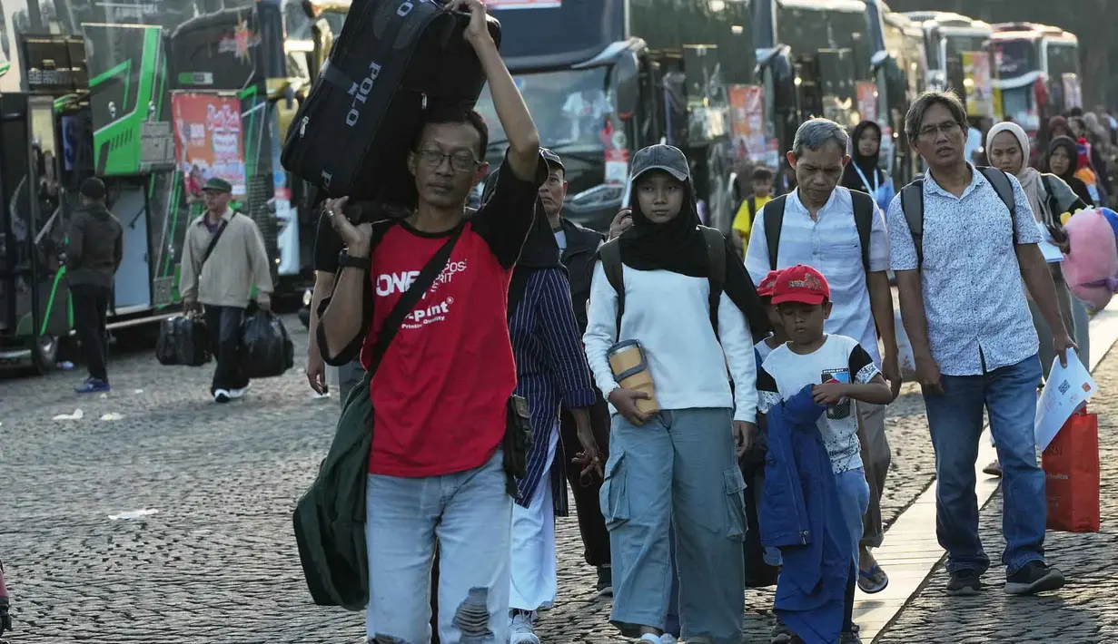 Program bertajuk "Aman Nyaman Bawa Cerita Bahagia" ini menggunakan 709 bus ke 20 kota/kabupaten tujuan. Tampak dalam foto, orang-orang membawa barang-barang mereka saat tiba untuk perjalanan mudik gratis yang diselenggarakan oleh Pemerintah Provinsi Jakarta di Lapangan Monumen Nasional, Selasa 17 Maret 2026. (AP Photo/Achmad Ibrahim)