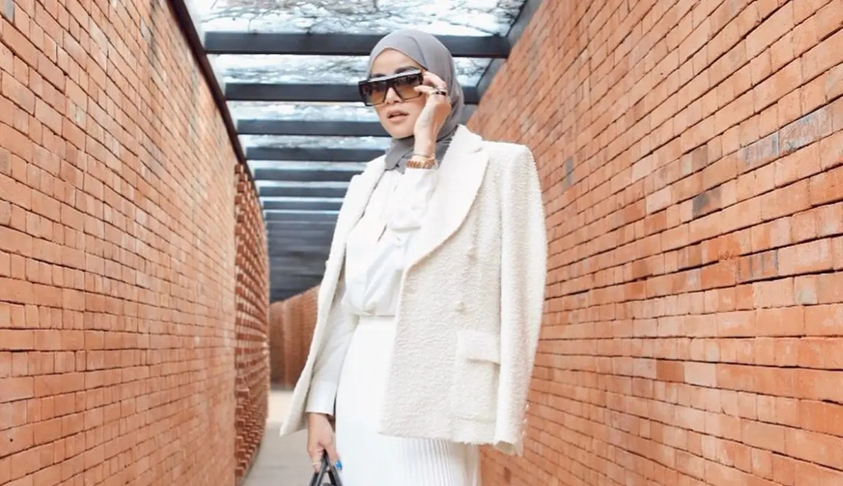 Memadukan busana serba putih lengkap dengan blazer, gaya penampilan Olla Ramlan satu ini curi perhatian netizen. Ia pun memilih menggunakan hijab berwarna abu-abu dan menggunakan kacamata sebagai pelengkap penampilan. (Liputan6.com/IG/@ollaramlan)