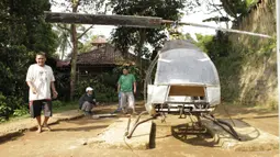 Gambar yang diambil pada 17 November 2019, Jujun Junaedi (kiri) menyelesaikan pembuatan helikopter buatannya di halaman belakang rumahnya di Sukabumi. Jujun yang berusia 41 tahun ini menargetkan helikopter berbahan bakar bensinnya rakitannya dapat diuji terbang pada akhir 2019. (Wulung WIDARBA/AFP)