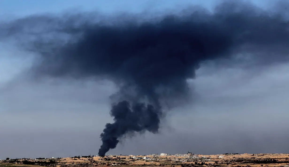 Sebuah foto yang diambil dari Israel selatan menunjukkan asap hitam mengepul di atas Jalur Gaza selama pengeboman Israel pada 18 Januari 2024. (JACK GUEZ/AFP)