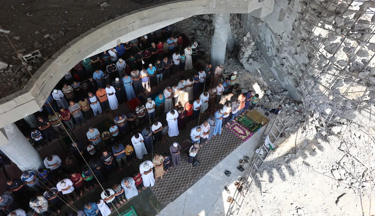 Umat Muslim Palestina melaksanakan salat Jumat di tengah puing-puing Masjid Albaani yang hancur di Khan Yunis, Jalur Gaza Selatan, pada 17 Oktober 2025. (Omar AL-QATTAA/AFP)