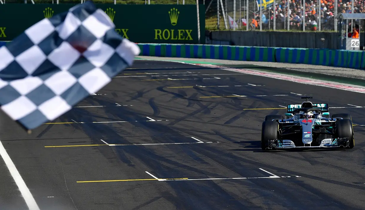 Lewis Hamilton saat berhasil finish diurutan pertama GP Hungaria di Sirkuit Hungaroring, Mogyorod, (29/7). Hamilton berhasil menjaga selisih 24 poin dari pesaing terdekatnya, pebalap Ferrari, Sebastian Vettel. (Andrej Isakovic/Pool Photo via AP)