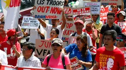 Demonstran membawa spanduk dan poster saat menggelar aksinya di Manila, Filipina (17/5). Mereka memprotes latihan militer Filipina-AS yang dijuluki "Balikatan 2017", yang berlangsung selama 10 hari. (AP Photo/Bullit Marquez)