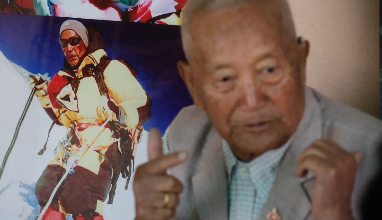 Min Bahadur Sherchan berbicara dengan Associated Press di samping foto dirinya saat mendaki Gunung Everest di Kathmandu, Nepal (11/4). Kakek Min ingin menjadi pendaki tertua yang berhasil menaklukkan Gunung Everest. (AP Photo / Niranjan Shrestha)