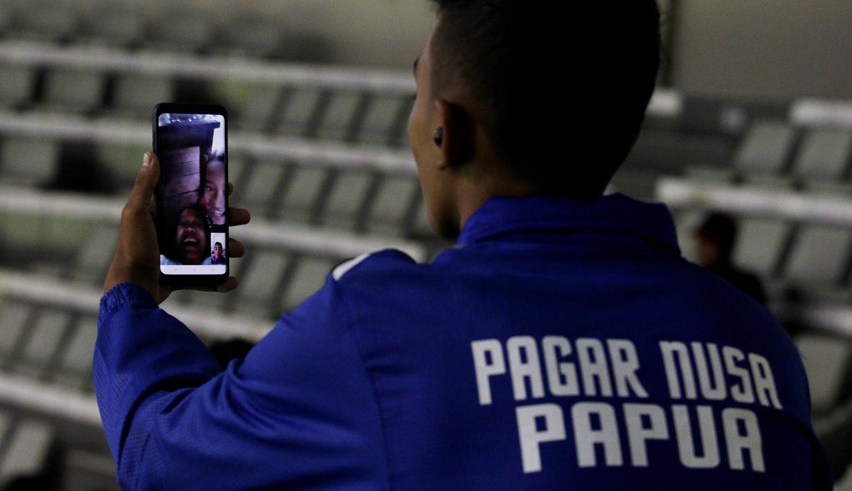 Seorang kontingen melakukan Video Call dengan keluarganya usai beraksi pada ajang Kejurnas Pagar Nusa di Padepokan Pencak Silat TMII, Jakarta, Minggu (6/1/2020). Sebanyak 487 pesilat dari seluruh Indonesia berpartisipasi dalam Kejurnas sekaligus Harlah ke-34 Pagar Nusa. (Bola.com/M Iqbal Ichsan)