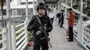 Seorang anggota Brimob bersenjata lengkap berjaga di JPO kawasan Bunderan HI, Jakarta, Jumat (11/5). Penjagaan tersebut dilakukan untuk antisipasi kegiatan Aksi 115 Pembebasan Baitul Maqdis yang berpusat di Monas. (Liputan6.com/Faizal Fanani)