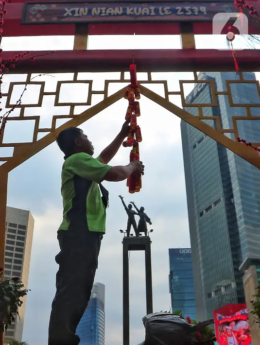Pekerja menyelesaikan pemasangan ornamen pernak pernik imlek di kawasan Bundaran HI (Hotel Indonesia), Jakarta, Sabtu (21/1/2023). Ornamen tersebut dipasang dalam rangka menyambut perayaan Tahun Baru Imlek 2574 Kongzili yang jatuh pada tanggal 22 Januari 2023 besok. (Liputan6.com/Angga Yuniar)