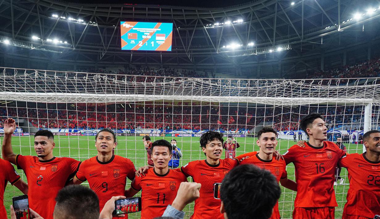 Sejumlah pemain China bernyanyi dengan para pendukung mereka setelah laga lanjutan putaran ketiga Grup C Kualifikasi Piala Dunia 2026 melawan Timnas Indonesia di Qingdao Youth Stadium, Qingdao, China, Selasa (15/10/2024). (AFP)