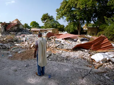 Seorang pria Israel yang mengenakan selendang berdoa di samping rumah-rumah yang dihancurkan oleh militan Hamas di Kibbutz Be'eri, Israel, Minggu (22/10/2023). Kibbutz tersebut dikuasai oleh militan Hamas dari dekat Jalur Gaza pada 7 Oktober lalu, ketika mereka membunuh dan menangkap banyak orang Israel. (AP Photo/Ariel Schalit)
