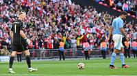 Kiper Arsenal, Aaron Ramsdale, melakukan selebrasi setelah berhasil menghalau tendangan penalti pemain Manchester City, Rodri, pada laga Community Shield di Stadion Wembley, London, Minggu (6/8/2023). Arsenal mengalahkan Manchester City 4-1 lewat adu penalti setelah bermain imbang 1-1 selama 90 menit. (AFP/Glyn Kirk)
