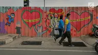 Pejalan kaki melintasi mural yang menghiasi tembok di kawasan Margonda, Depok, Sabtu (16/2). Gambar mural memiliki pesan agar masyarakat tetap damai dan berteman meski berbeda dalam memilih calon presiden dalam Pilpres 2019. (Liputan6.com/Herman Zakharia)