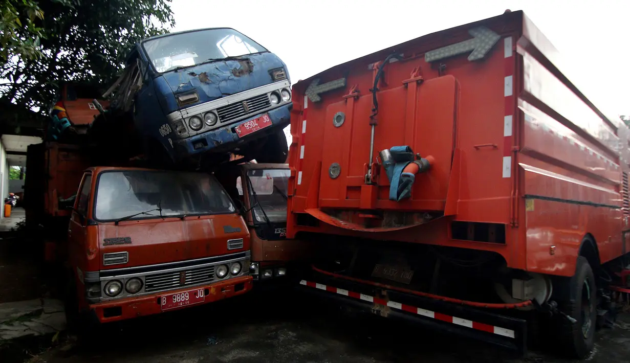 Penampakan bangkai armada truk sampah di Kantor Suku Dinas Lingkungan Hidup, Jakarta Barat, Selasa (27/3). Sebanyak 30 armada truk sampah diparkir dengan cara ditumpuk. (Liputan6.com/JohanTallo)