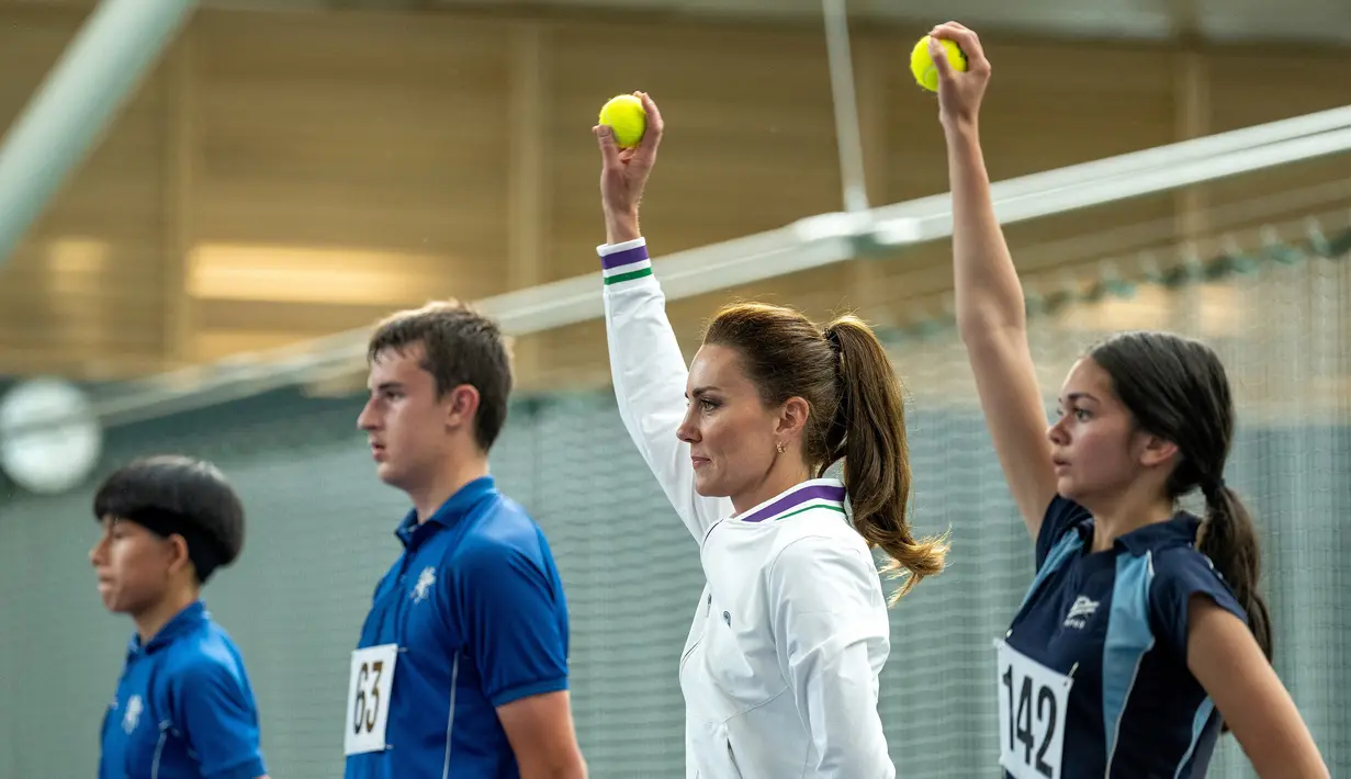 Princess of Wales, Kate Middleton (dua kanan), mempraktekan apa yang biasa dilakukan ball boy disela-sela pertandingan ekshibisi melawan Roger Federer jelang Turnamen Tenis Grand Slam Wimbledon 2023 di The All England Tennis Club in Wimbledon, Sabtu (24/6/2023). (AFP/AELTC/Thomas Lovelock)