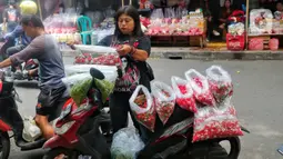 Peziarah yang datang ke pemakaman, membawa berkah bagi pedagang bunga tabur. Mereka meraup keuntungan dari hasil penjualannya. (Liputan6.com/Angga Yuniar)